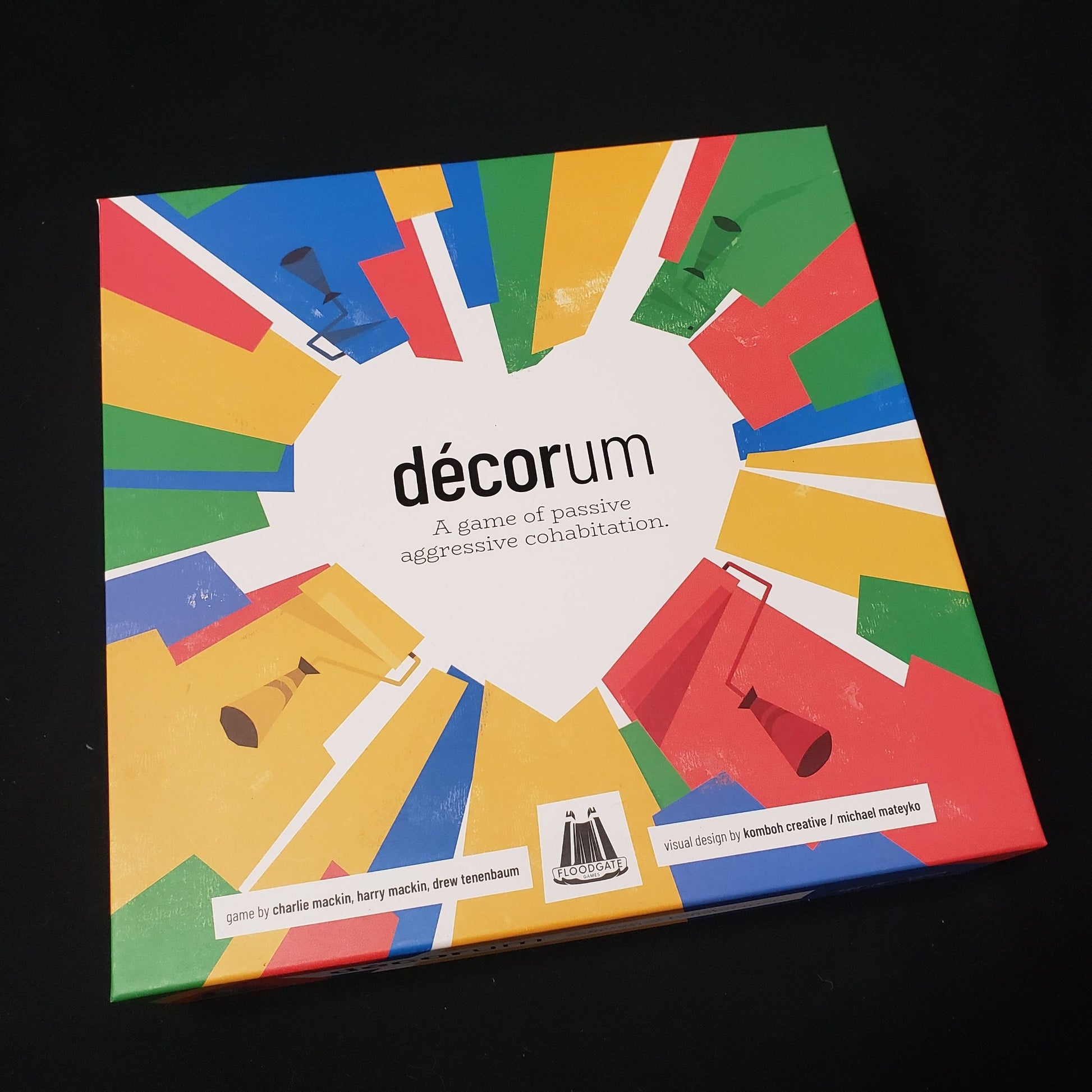 Image shows the front cover of the box of the Decorum board game