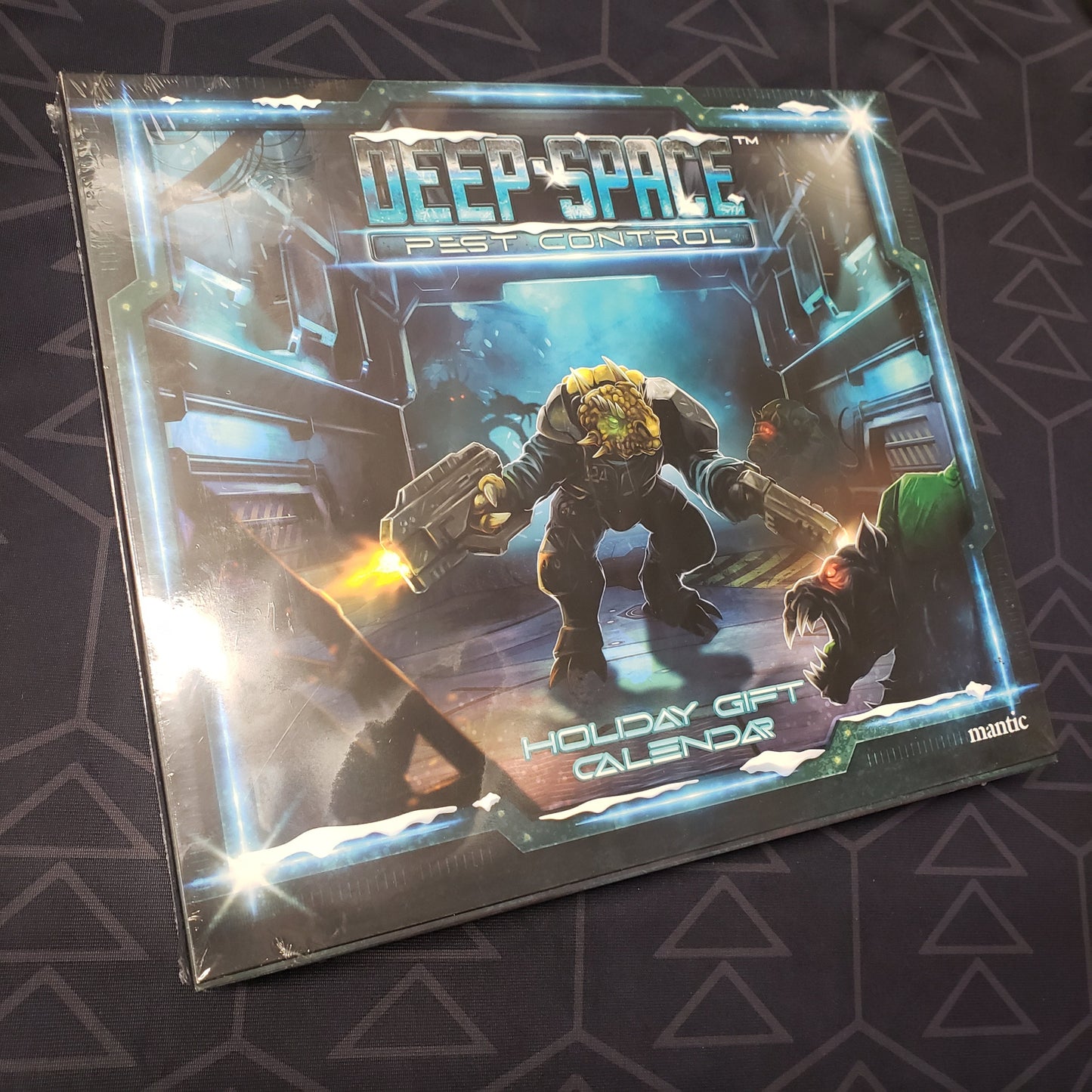 Image shows the front cover of the box for the Deep Space Pest Control Holiday  gaming Gift Calendar