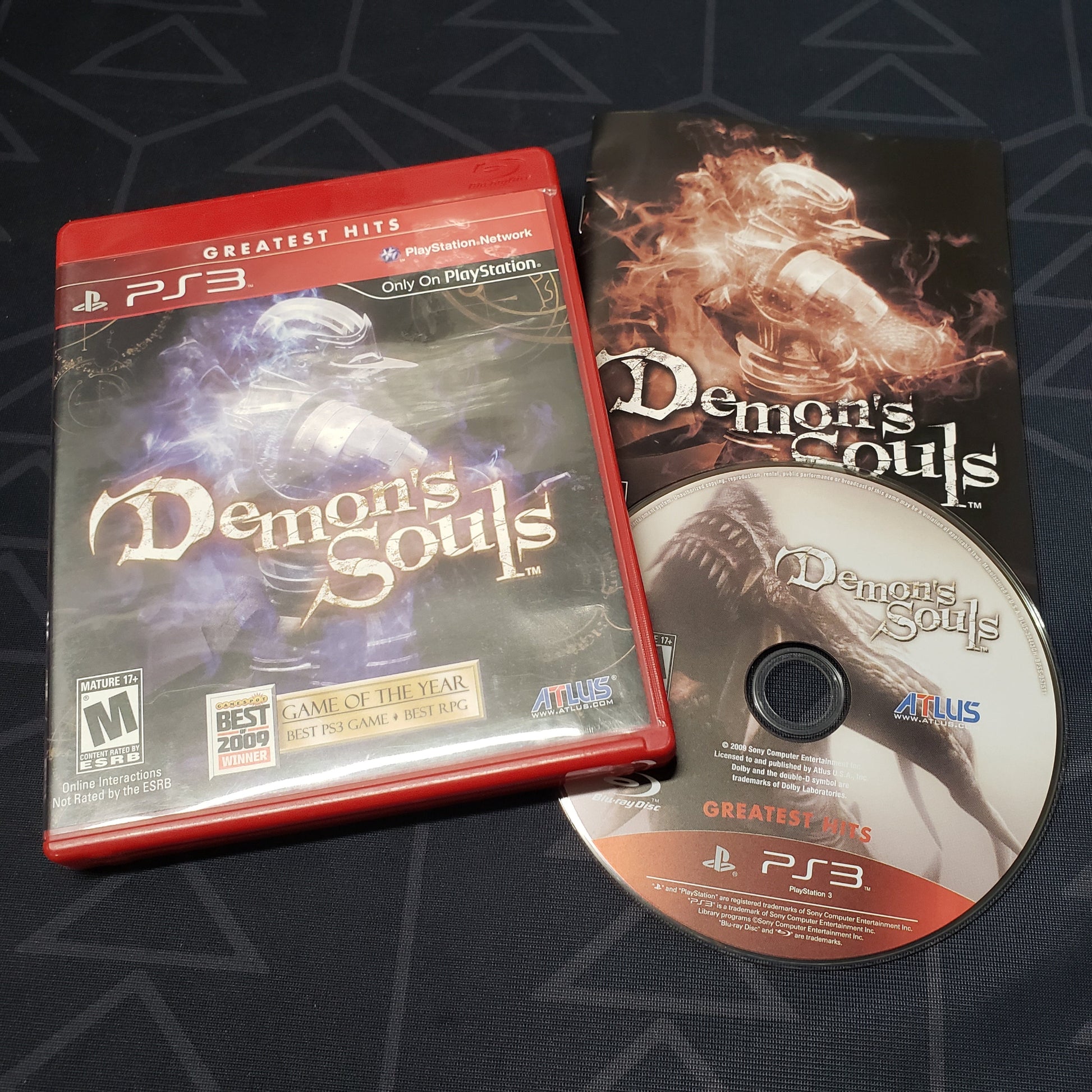 Image shows the case, manual and disc for the video game Demon's Souls for Playstation 3