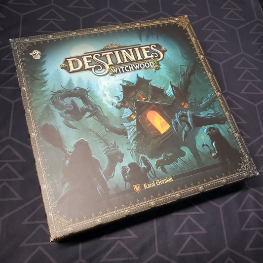 Image shows the front cover of the box of the Witchwood expansion for the board game Destinies