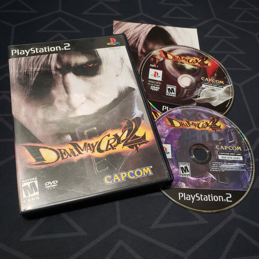 Image shows the case, manual and two discs for the video game Devil May Cry 2 for Playstation 2