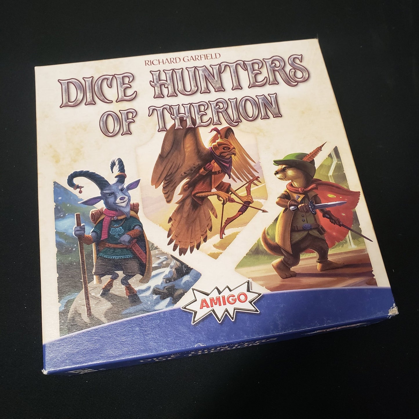 Image shows the front cover of the box of the Dice Hunters of Therion board game