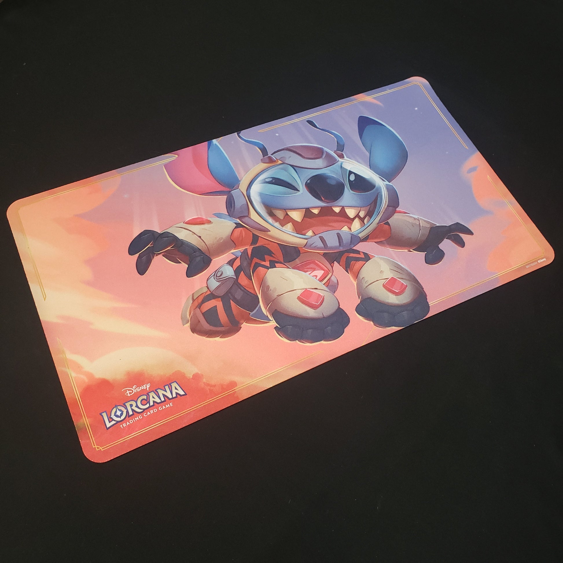 Image shows a gaming playmat featuring Into the Inklands: Stitch, Little Rocket art for the Disney Lorcana card game