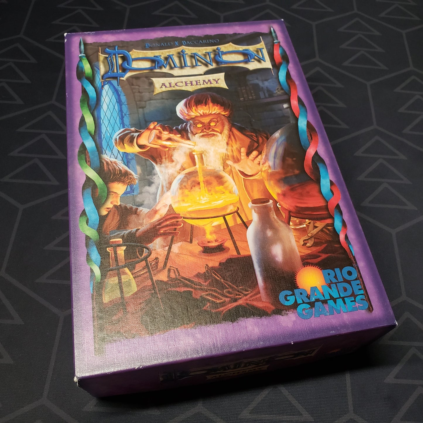 Image shows the front cover of the box of the Alchemy expansion for the card game Dominion