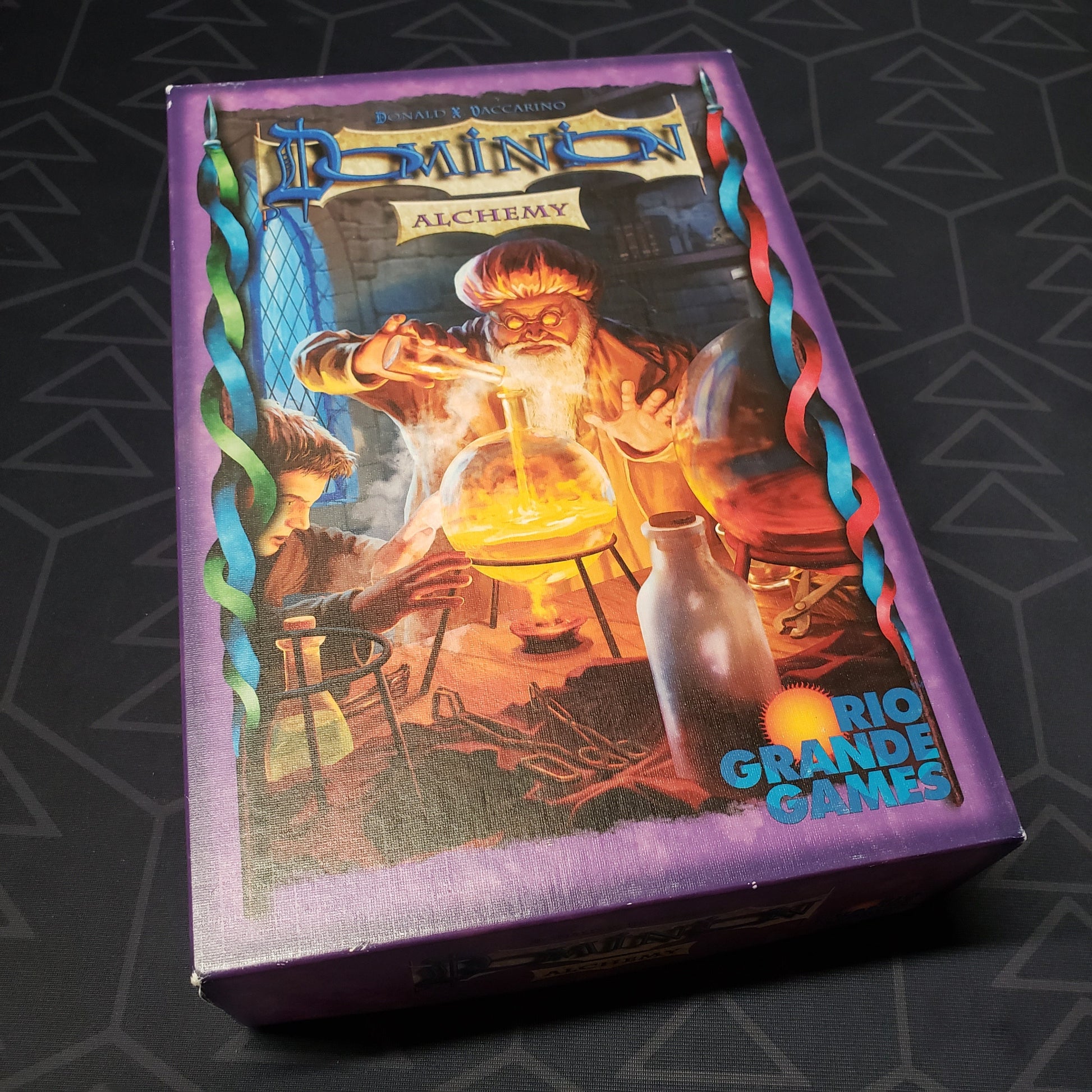 Image shows the front cover of the box of the Alchemy expansion for the card game Dominion