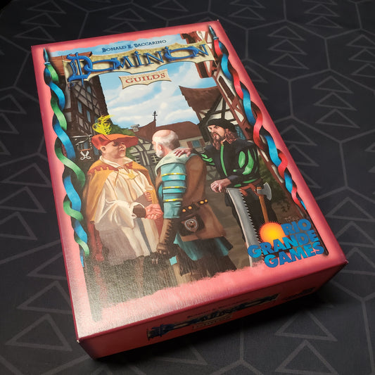 Image shows the front cover of the box of the Guilds expansion for the card game Dominion