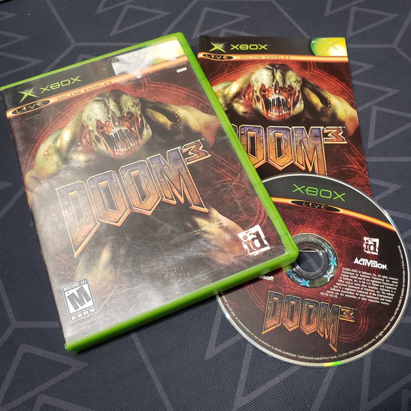 Image shows the case, manual and disc for the video game Doom 3 for the original Xbox