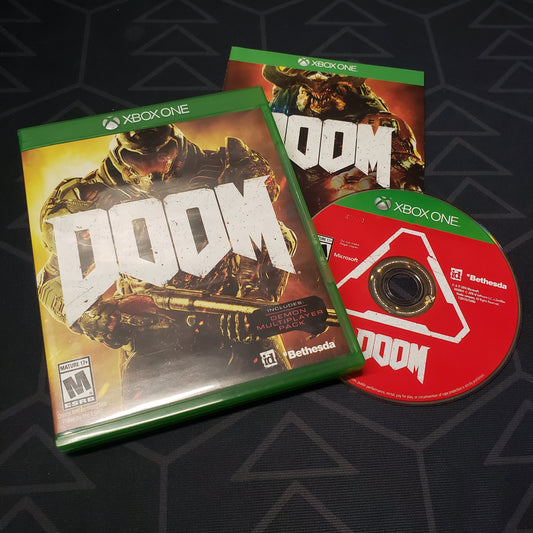 Image shows the case, manual and disc for the video game Doom for Xbox One
