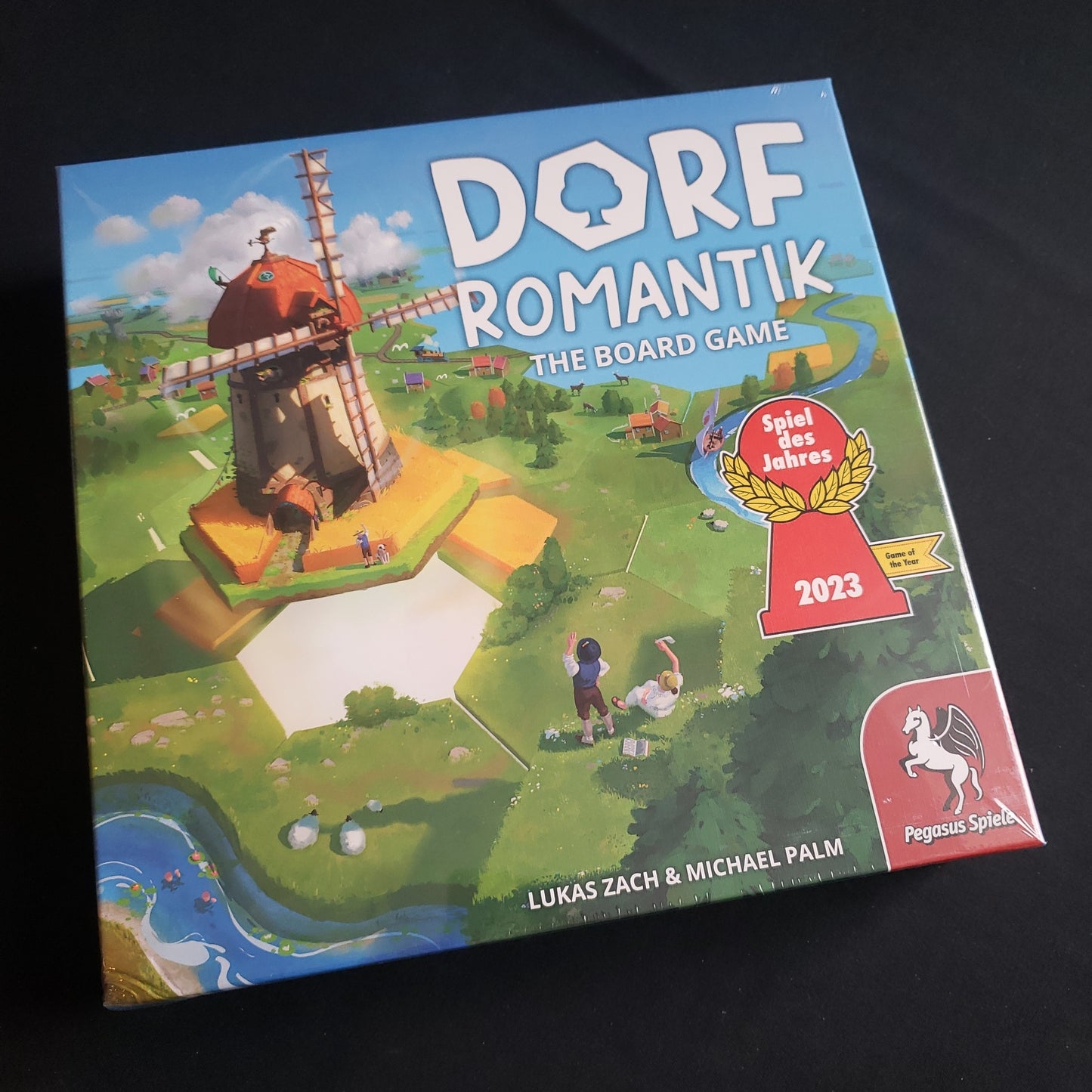 Image shows the front cover of the box of Dorfromantik: The Board Game
