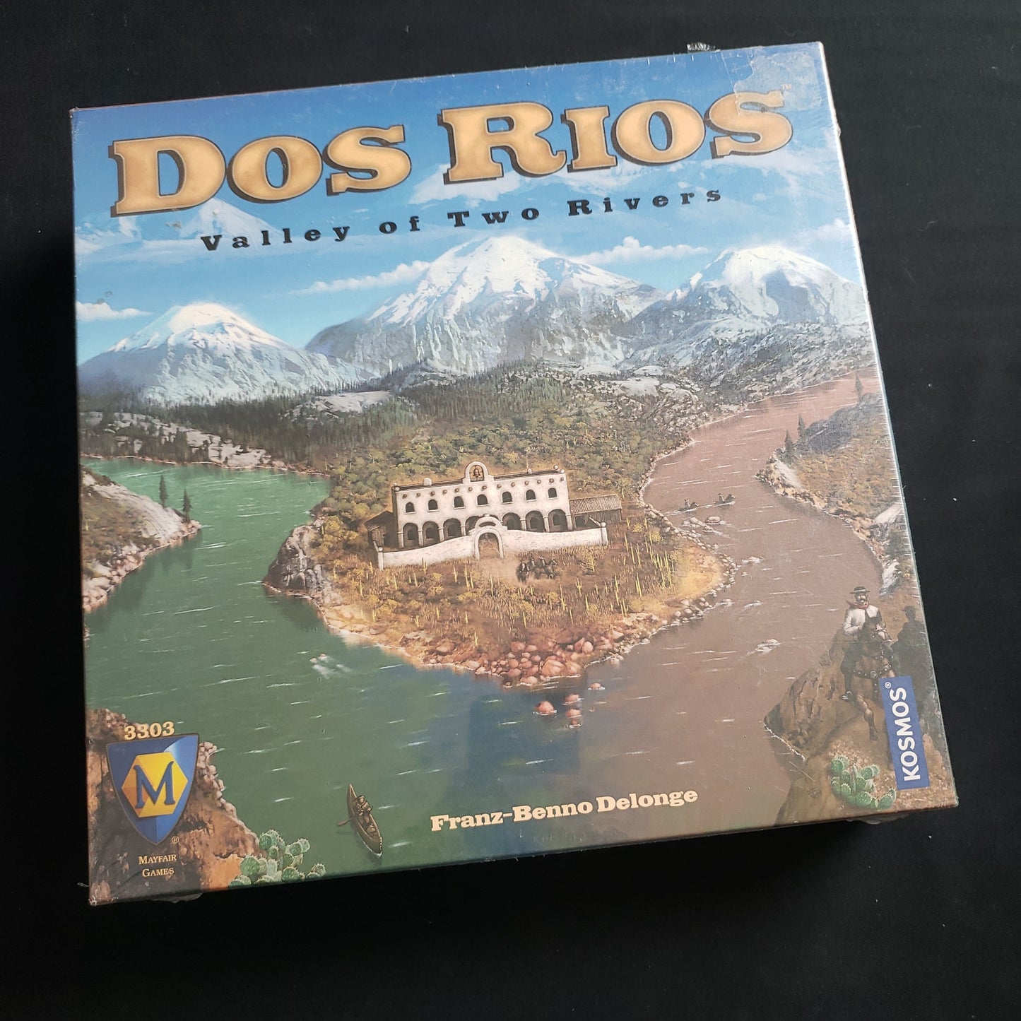 Image shows the front cover of the box of the Dos Rios board game