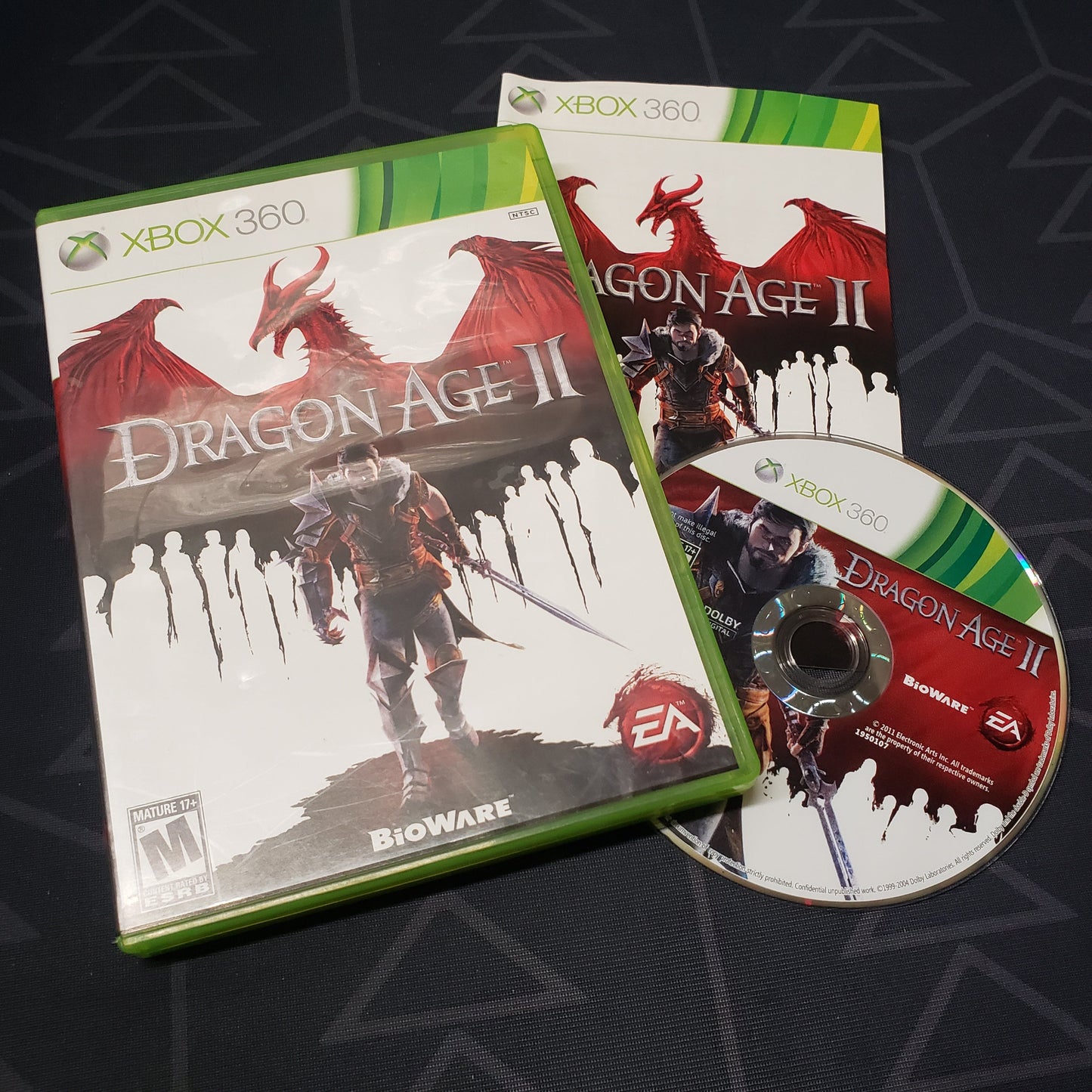 Image shows the case, manual and disc for the video game Dragon Age II for Xbox 360