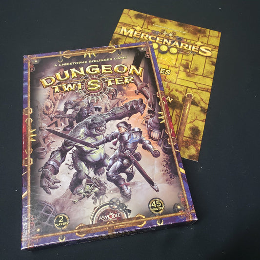 Image shows the front cover of the box of the Dungeon Twister board game sitting on top of the Mercenaries expansion instruction booklet