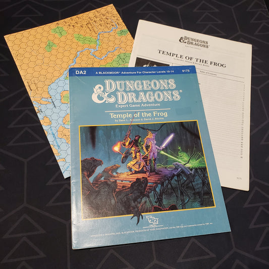 Image shows the front cover of the folio for the Temple of the Frog adventure module for the roleplaying game Dungeons & Dragons 1E with the booklet & map fanned out