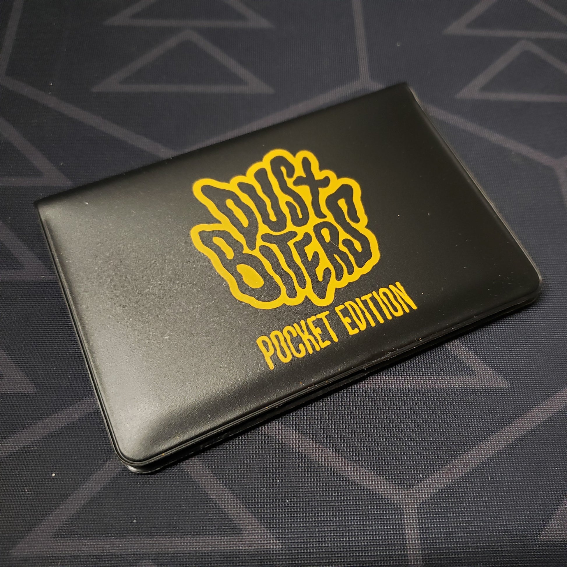 Image shows the front of the card wallet for the card game Dustbiters: Pocket Edition