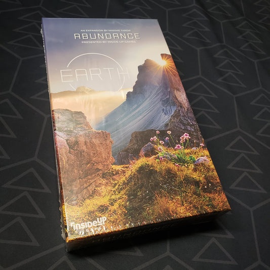 Image shows the front cover of the box of the Abundance expansion for the board game Earth