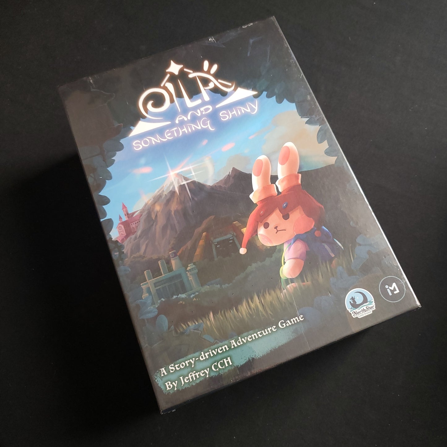 Image shows the front cover of the box of the Eila & Something Shiny board game