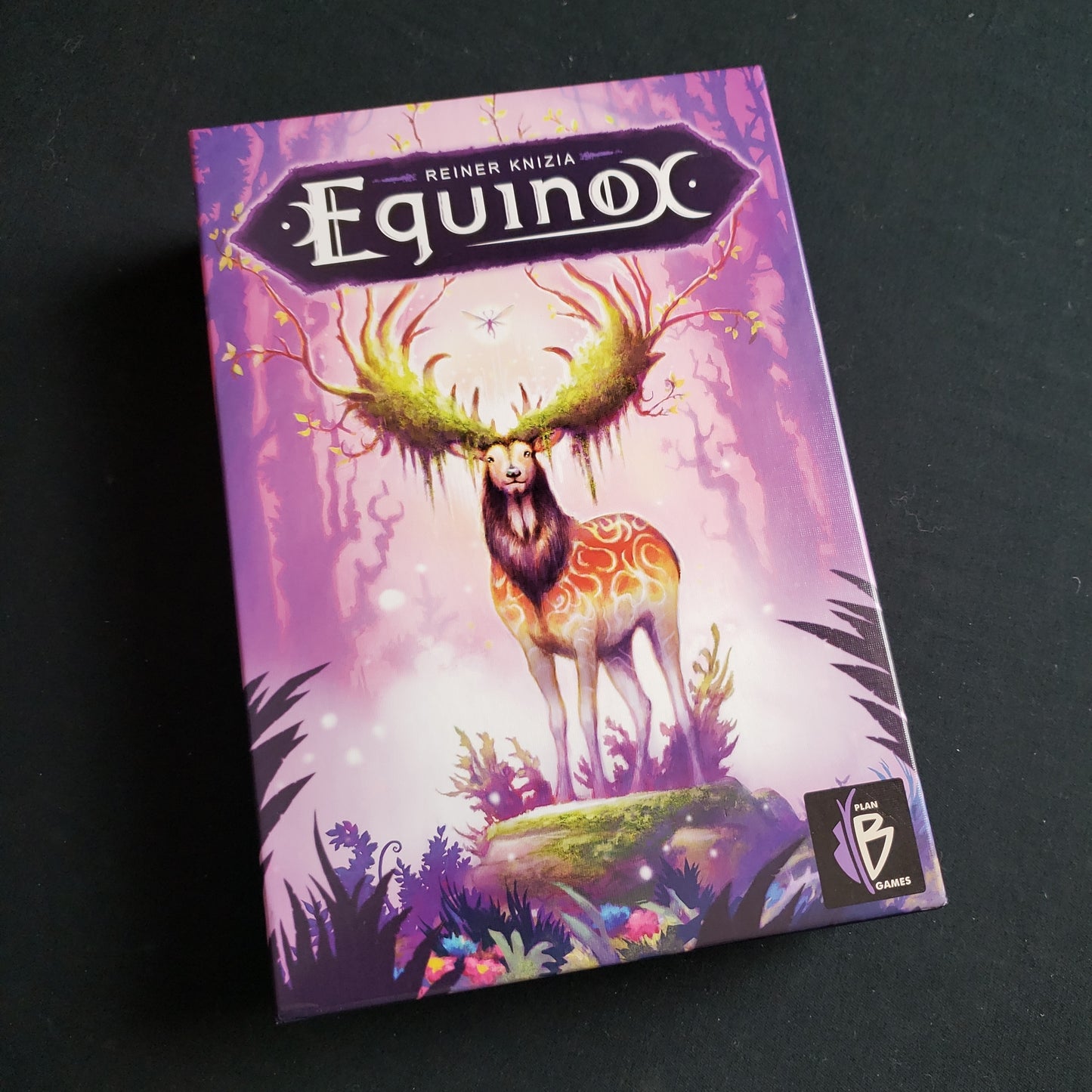Image shows the front cover of the box of the Equinox board game