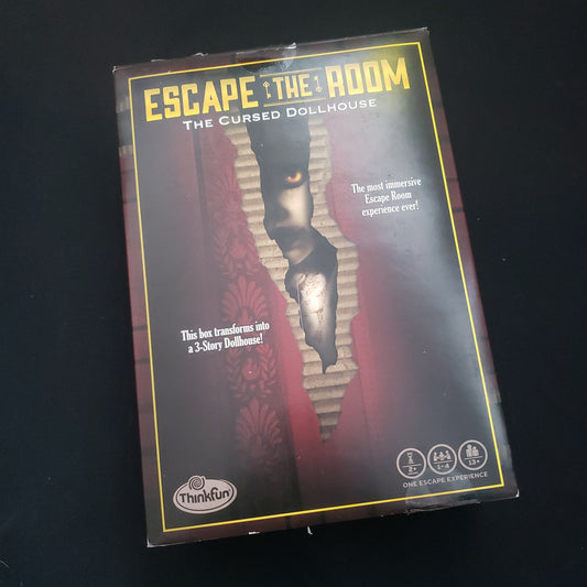Image shows the front cover of the box of the Escape the Room: The Cursed Dollhouse puzzle game