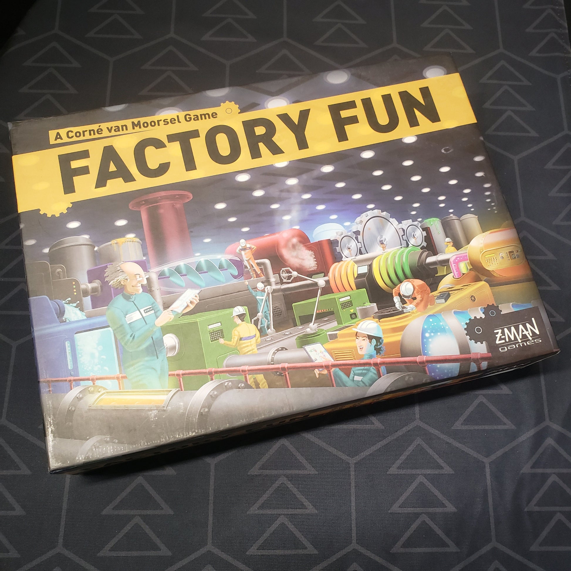Image shows the front cover of the box for the Factory Fun board game