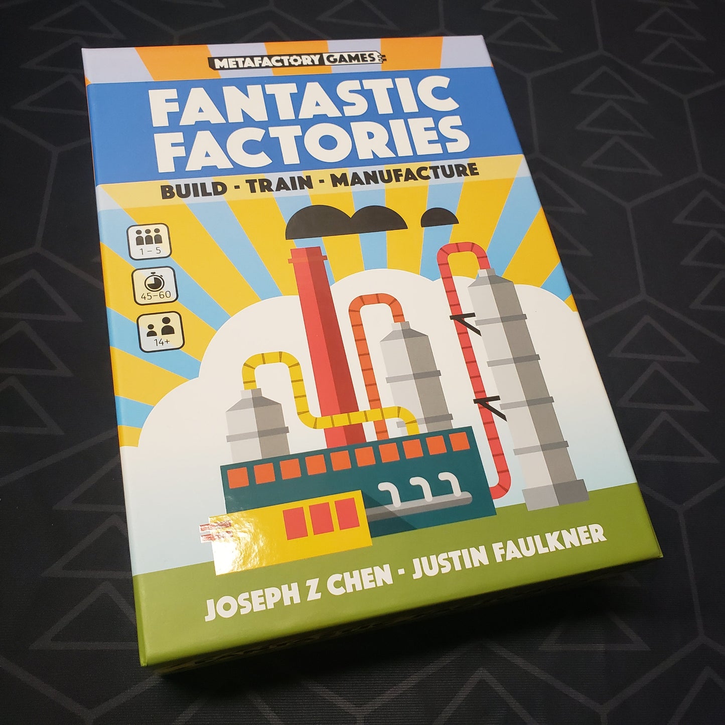 Image shows the front cover of the box for the Fantastic Factories board game