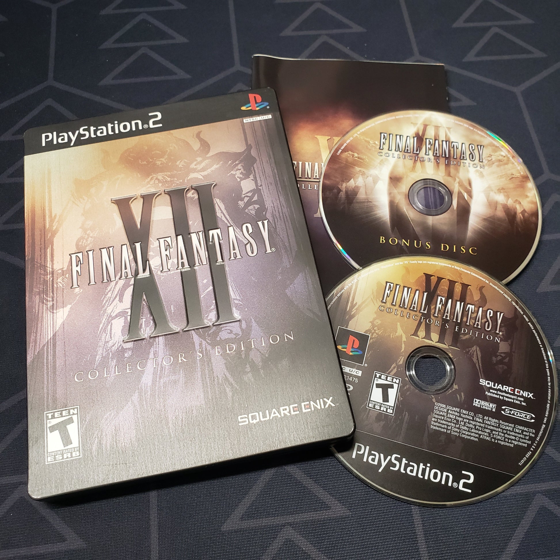 Image shows the steelbook case, manual and two discs for the video game Final Fantasy XII: Collector's Edition for Playstation 2