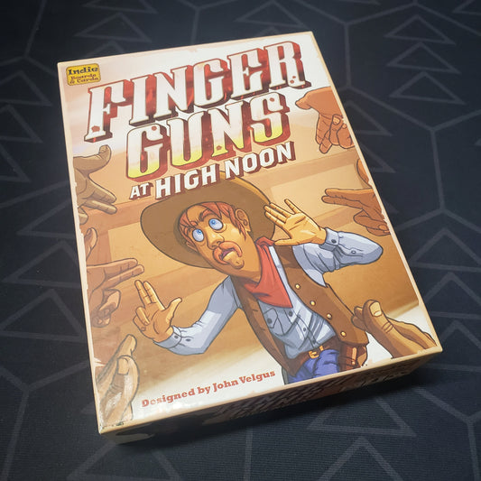 Image shows the front cover of the box for the Finger Guns at High Noon party game