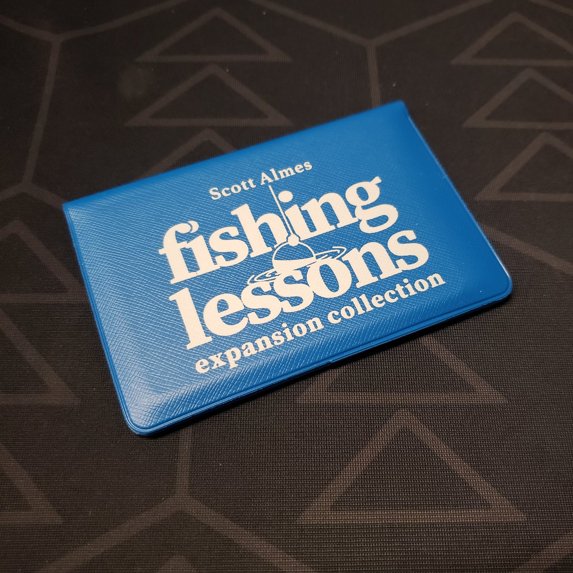Image shows the front of the card wallet of the Expansion Collection for the card game Fishing Lessons