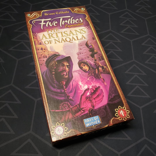 Image shows the front cover of the box of the Artisans of Naqala expansion for the board game Five Tribes