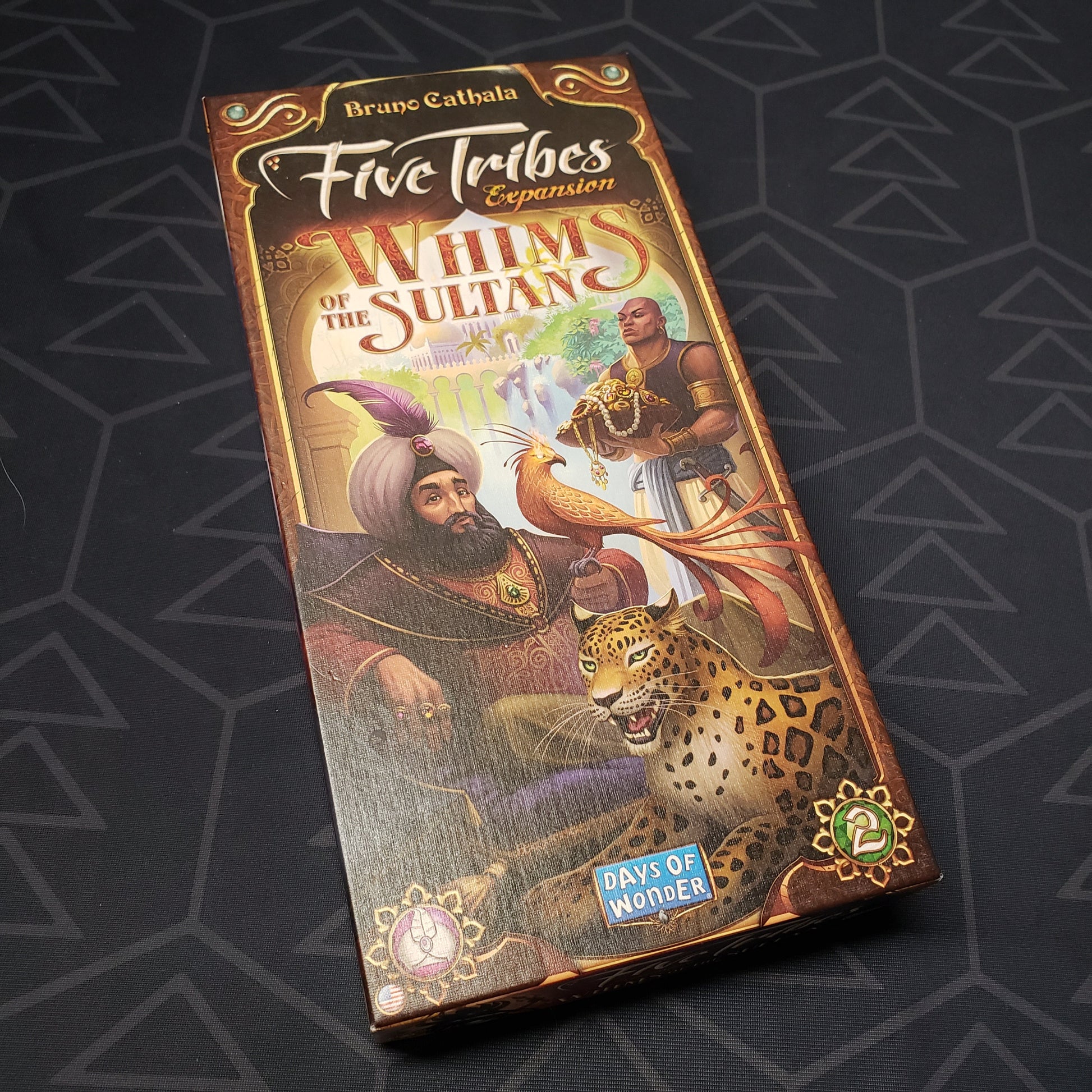 Image shows the front cover of the box of the Whims of the Sultan expansion for the board game Five Tribes