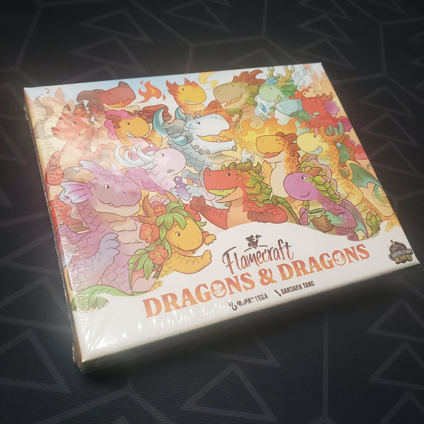 Image shows the front cover of the box of the Dragons & Dragons expansion for the board game Flamecraft