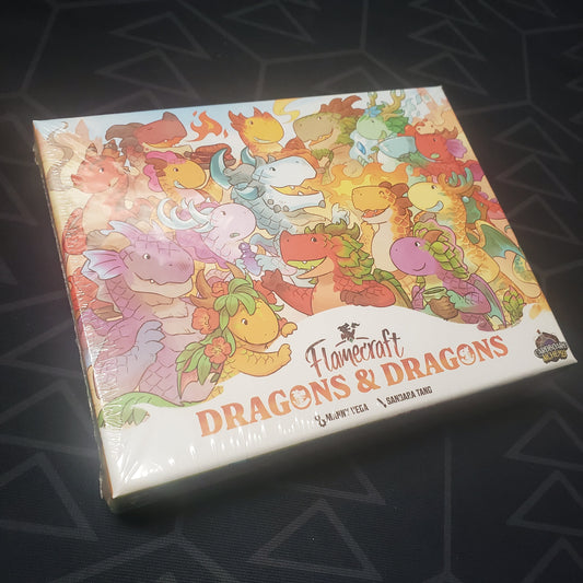 Image shows the front cover of the box of the Dragons & Dragons expansion for the board game Flamecraft