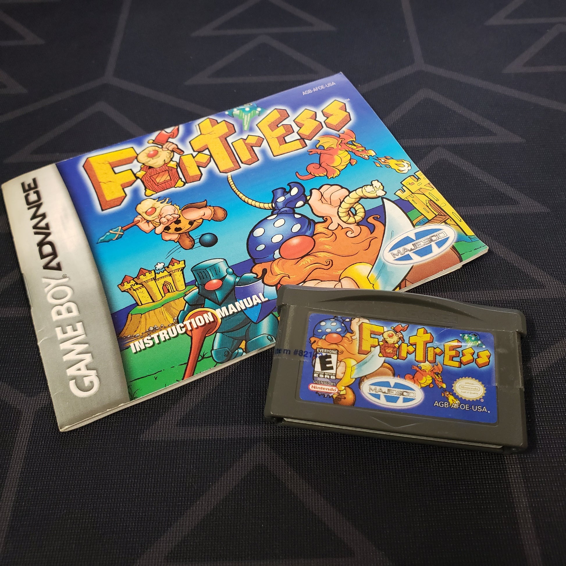 Image shows the manual & cartridge for the video game Fortress for Nintendo Game Boy Advance