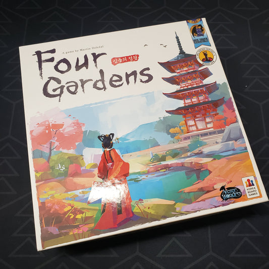 Image shows the front cover of the box for the Four Gardens board game
