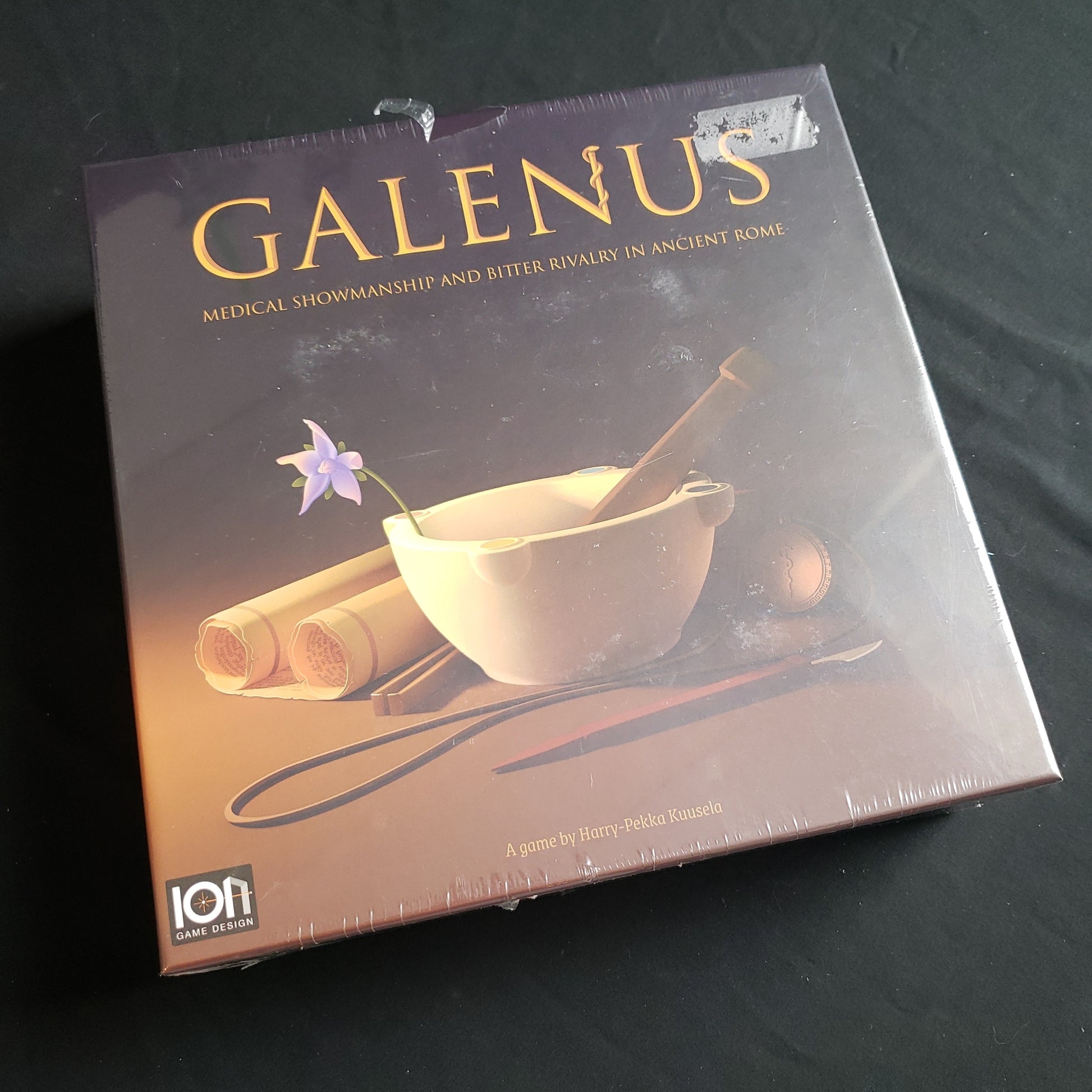 Image shows the front cover of the box of the Galenus board game