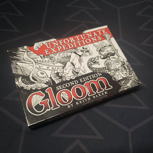 Image shows the front cover of the box of the Unfortunate Expeditions expansion for the card game Gloom (Second Edition)