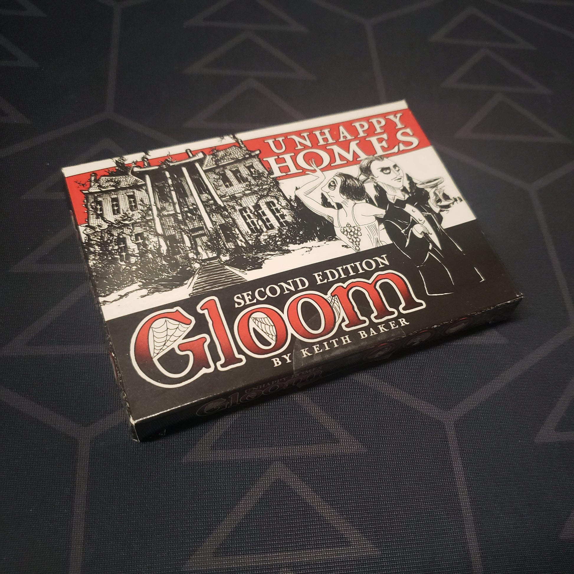Image shows the front cover of the box of the Unhappy Homes expansion for the card game Gloom (Second Edition)