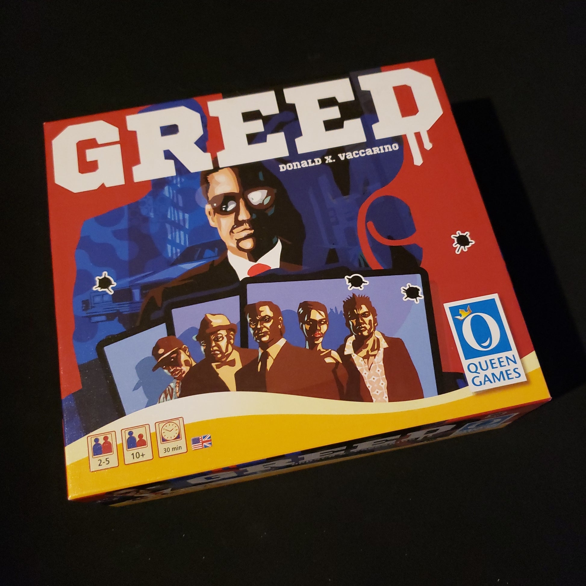 Image shows the front cover of the box of the Greed card game