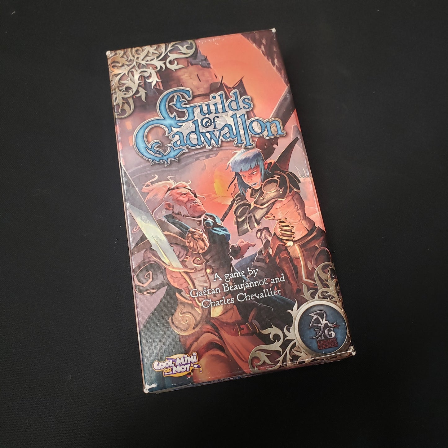 Image shows the front cover of the box of the Guilds of Cadwallon board game