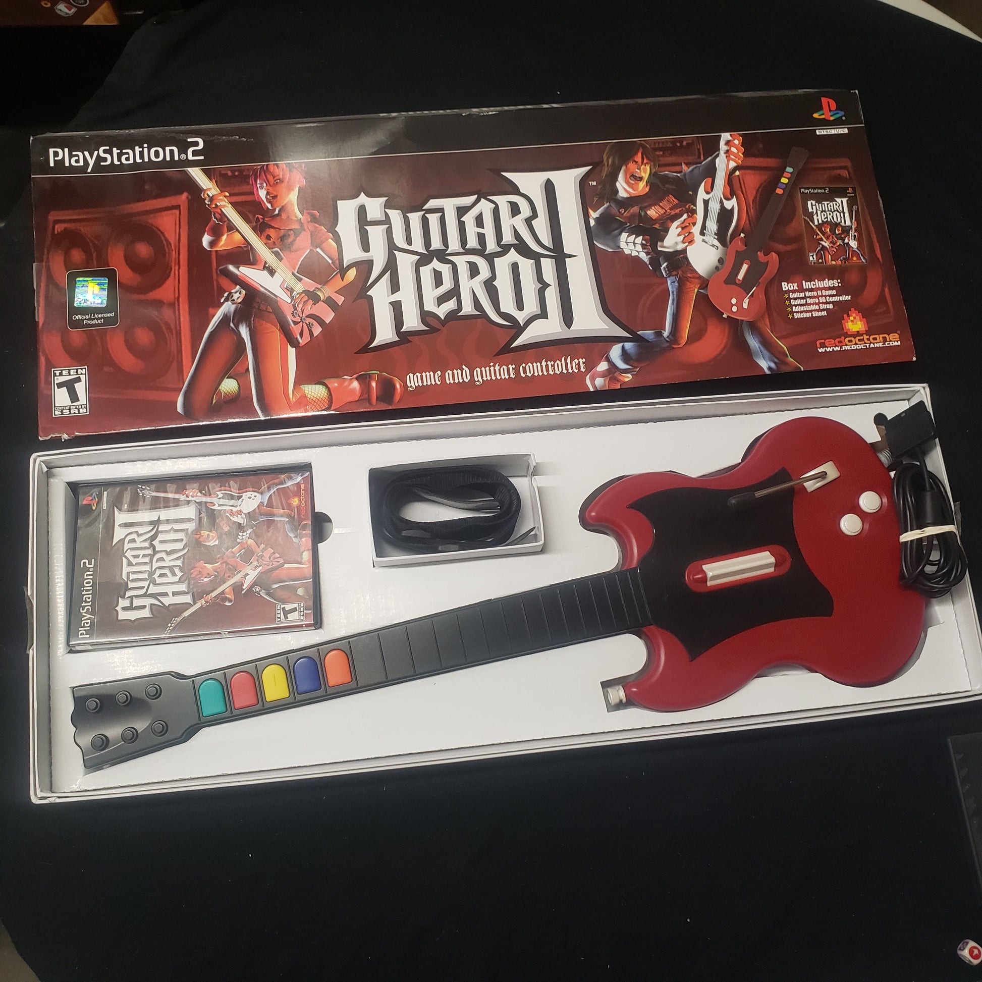 Image shows the box and components of the SG Guitar Bundle for the video game Guitar Hero II for Playstation 2