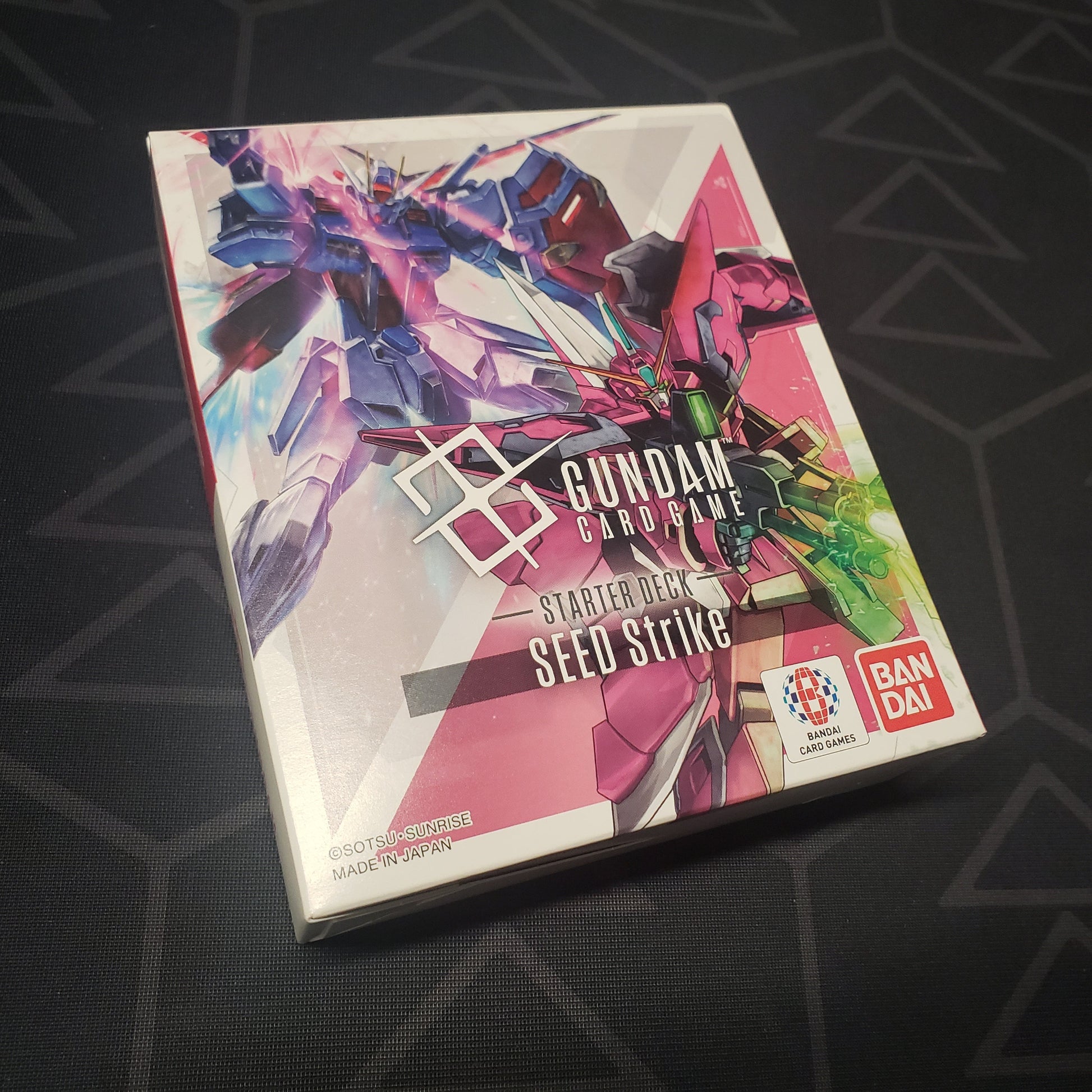 Image shows the front cover of the box of the Seed Strike Starter Deck for the Gundam Card Game