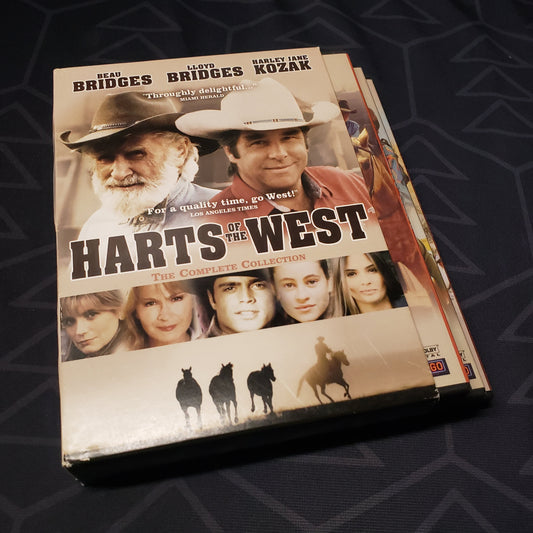 Image shows the outer box and three fanned-out disc cases for the complete series set of Harts of the West on DVD