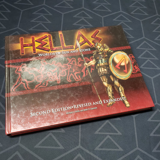 Image shows the front cover of the core rulebook for the roleplaying game HELLAS: Worlds of Sun and Stone