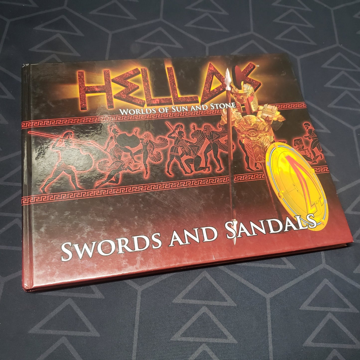 Image shows the front cover of the Swords and Sandals book for the roleplaying game HELLAS: Worlds of Sun and Stone