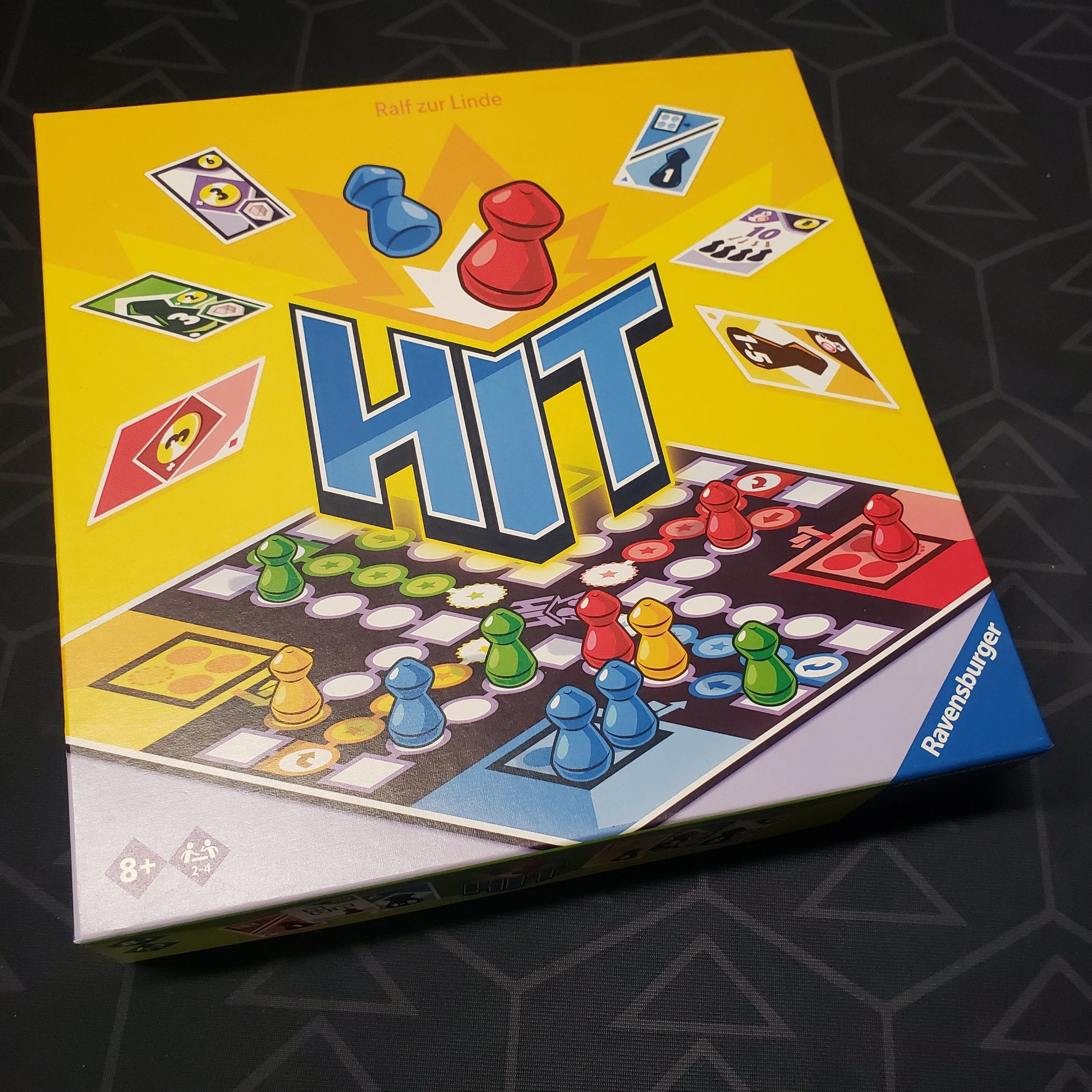 Image shows the front cover of the box for the HIT board game