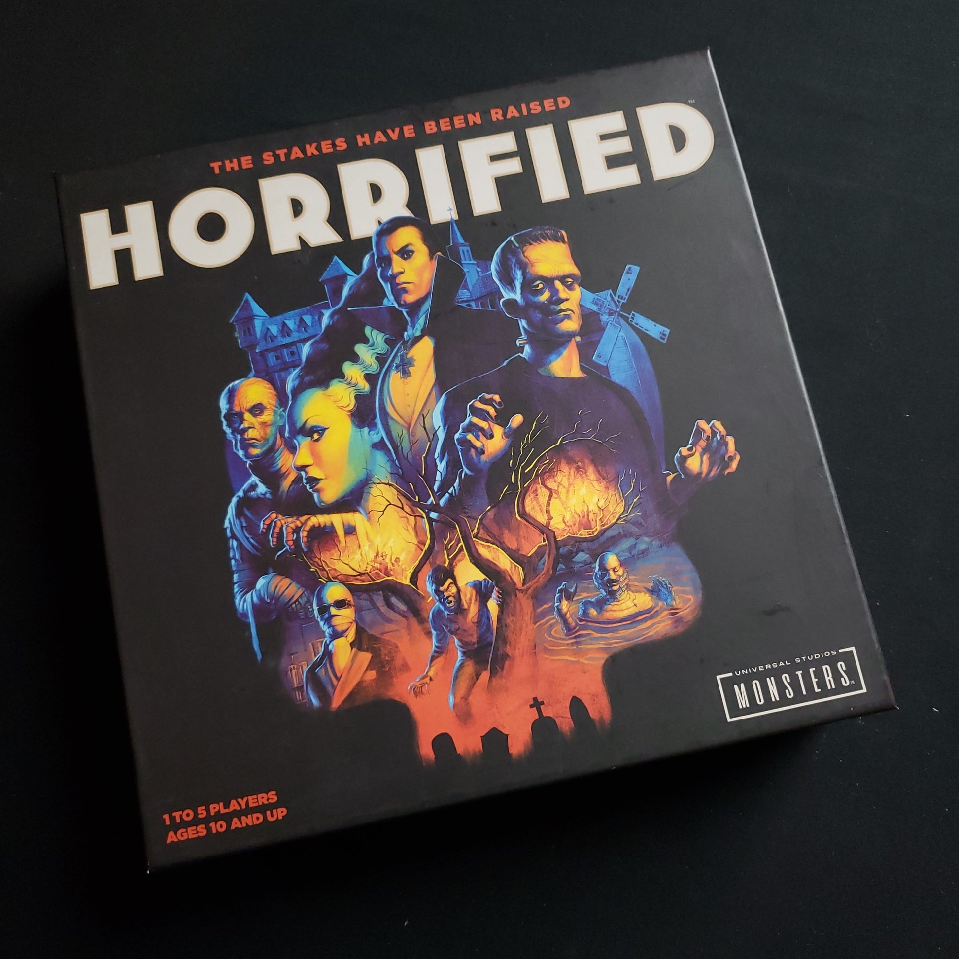 Image shows the front cover of the box of the Horrified board game