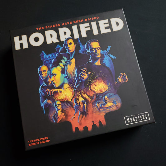 Image shows the front cover of the box of the Horrified board game