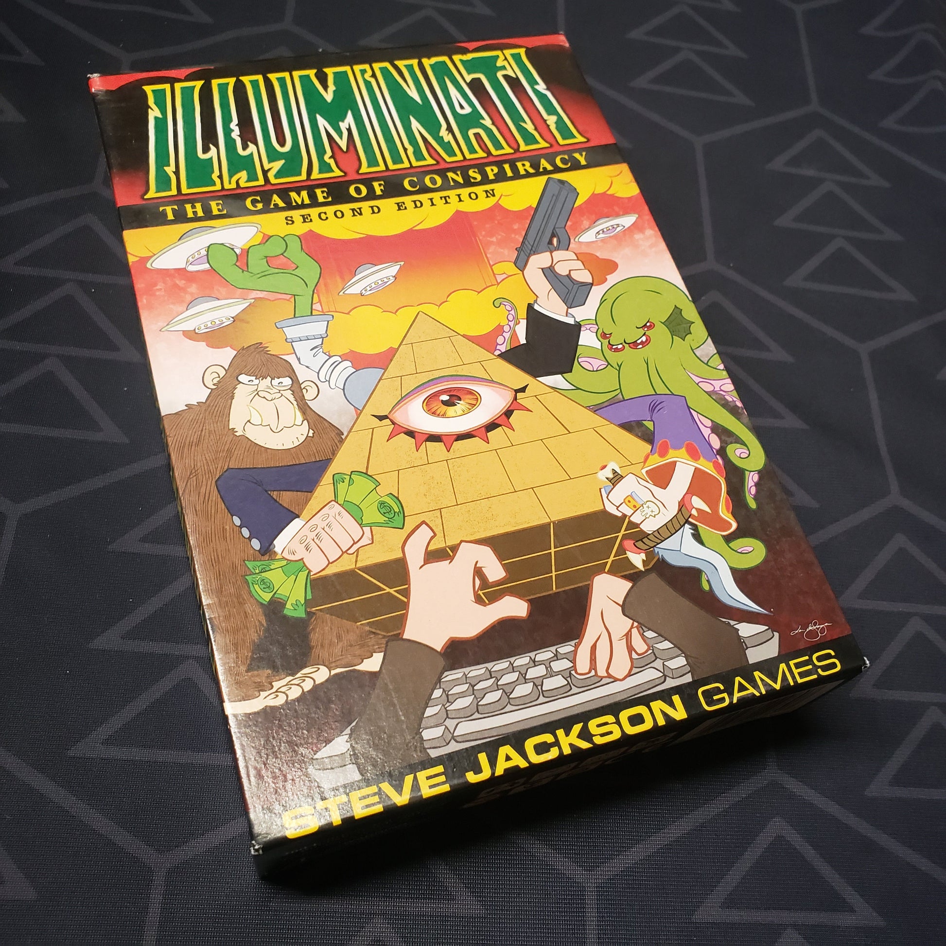 Image shows the front cover of the box for the second edition of the card game Illuminati