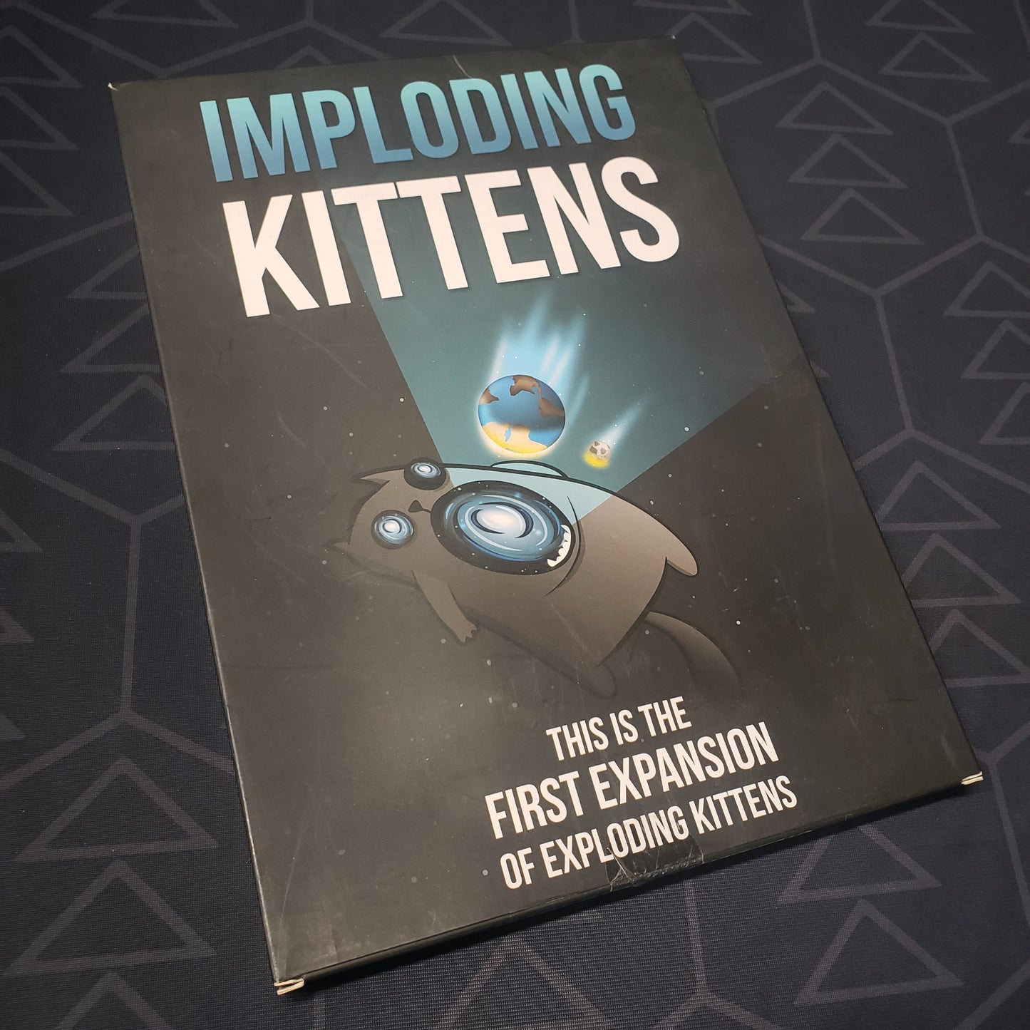 Image shows the front cover of the box of the Imploding Kittens expansion for the card game Exploding Kittens