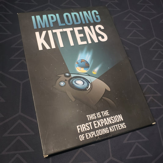 Image shows the front cover of the box of the Imploding Kittens expansion for the card game Exploding Kittens