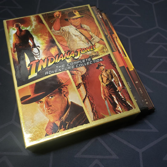 Image shows the outer box and four fanned-out cases for the movie set of Indiana Jones: The Complete Adventure Collection on DVD